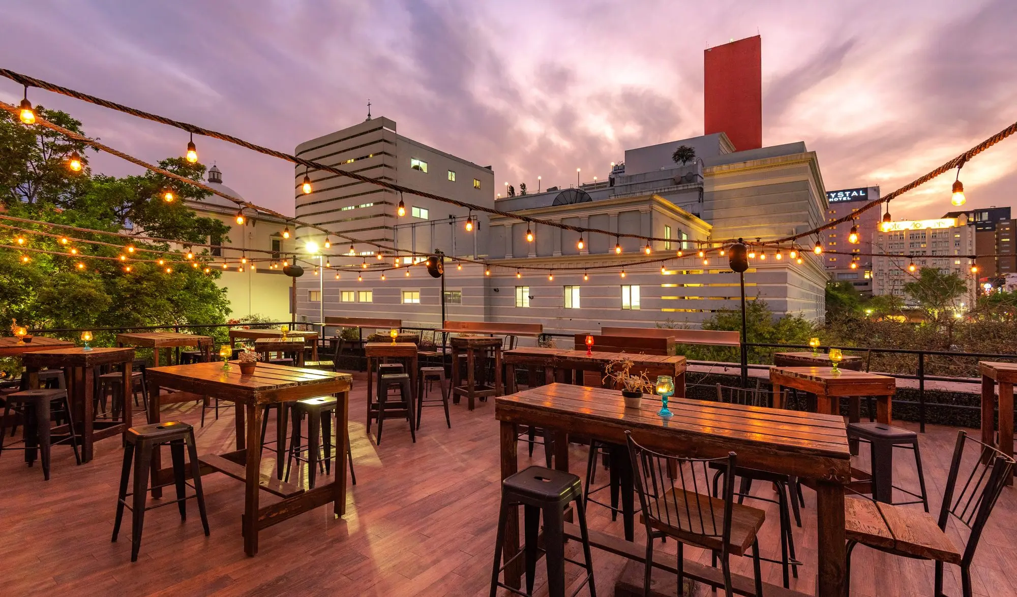 La Terraza Coss al atardecer, con las mesas altas y la ciudad al fondo