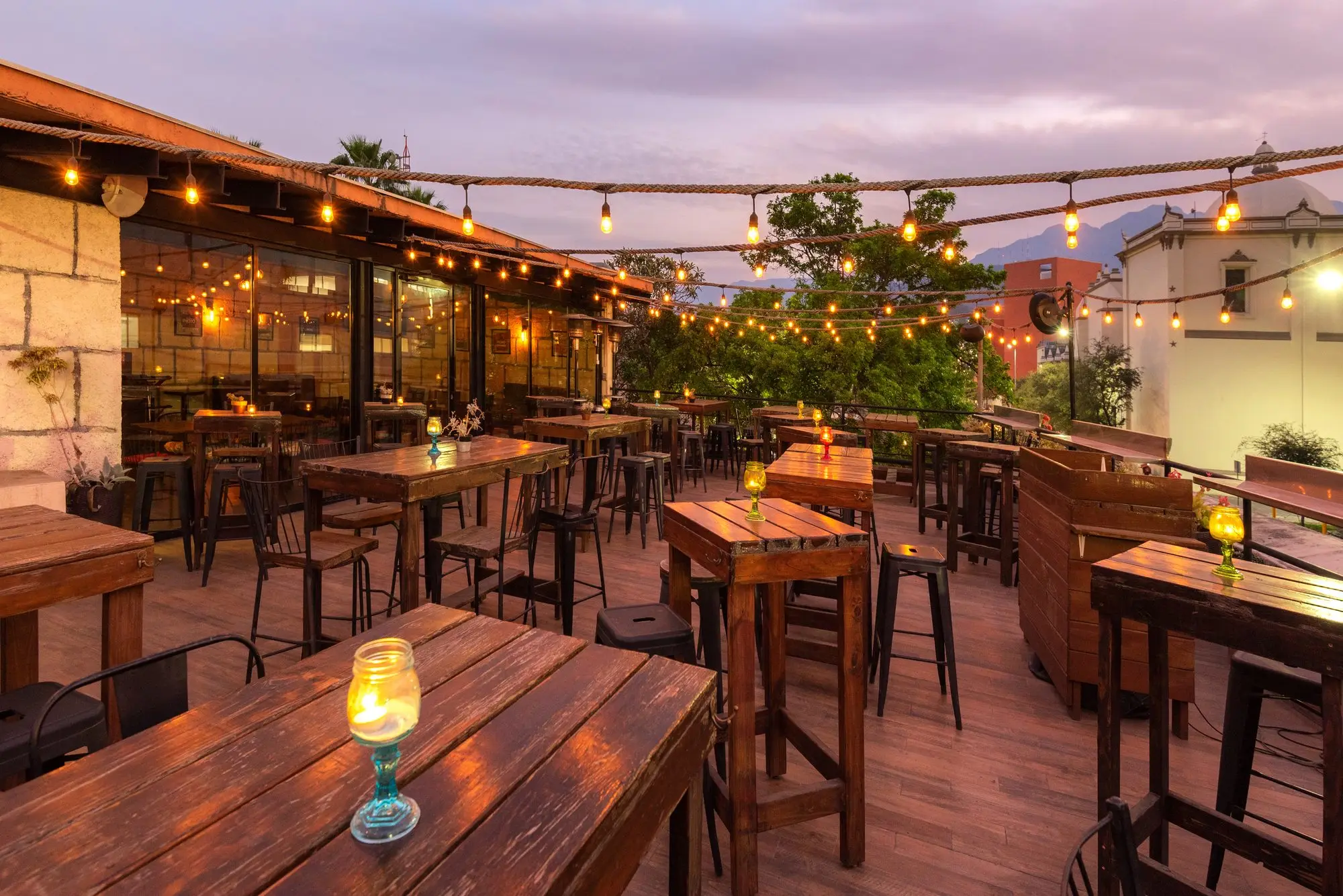 Las series de luz encendidas sobre las mesas de la Terraza, al caer la tarde