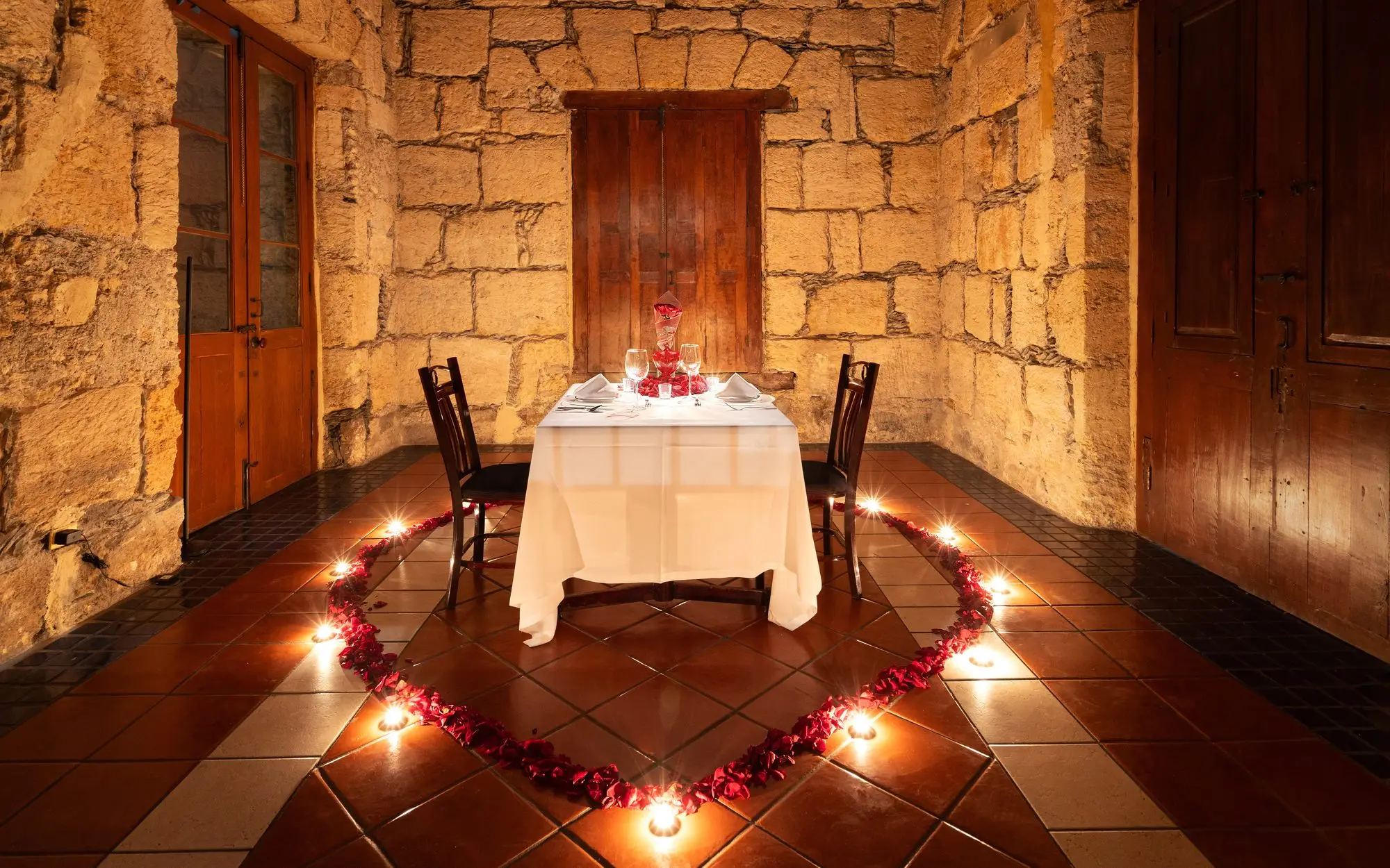 El Salón del Jefe en montaje romántico, con el corazón de pétalos y velas en el piso