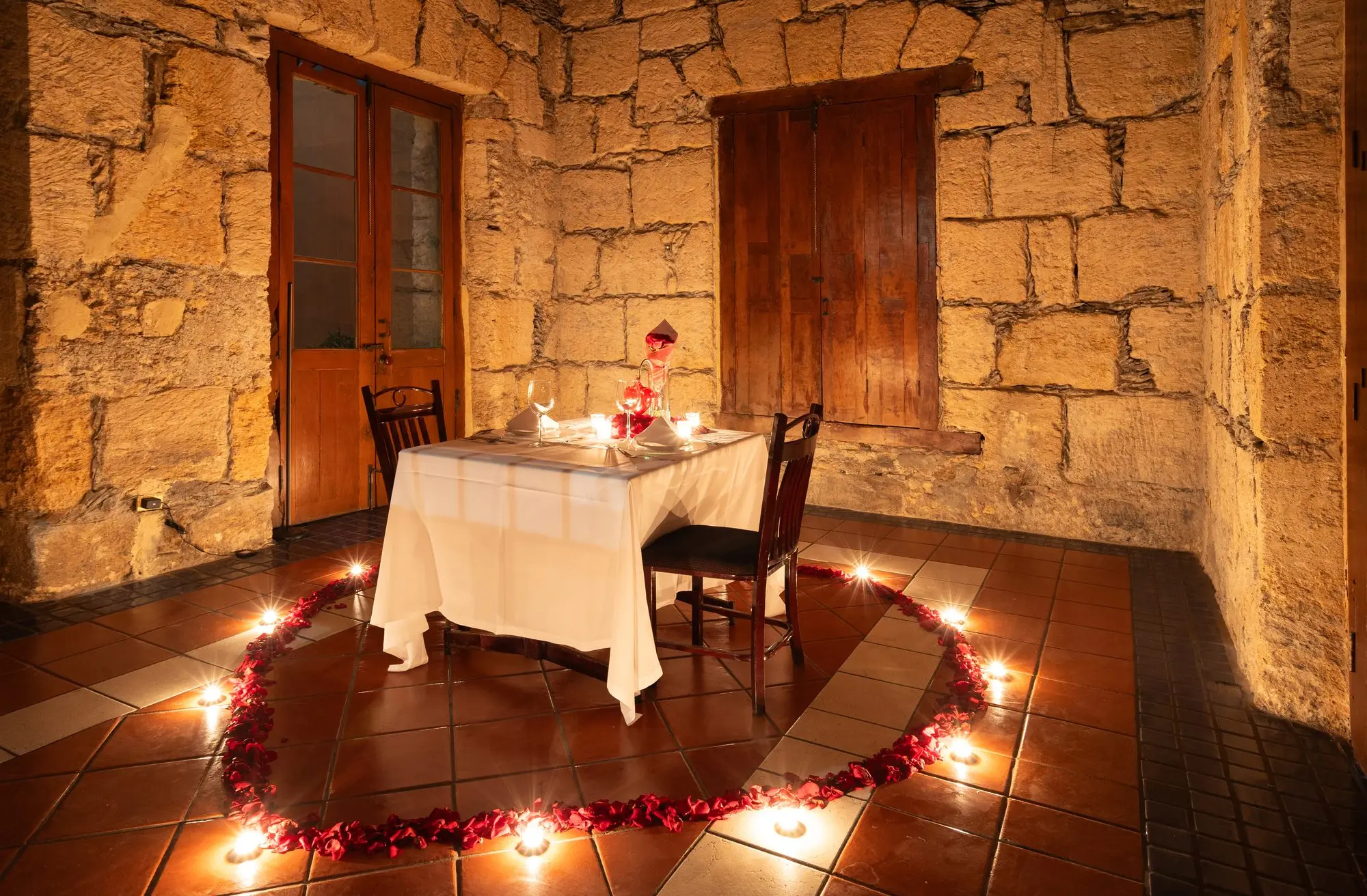 La mesa para dos del montaje romántico, rodeada por el corazón de velas