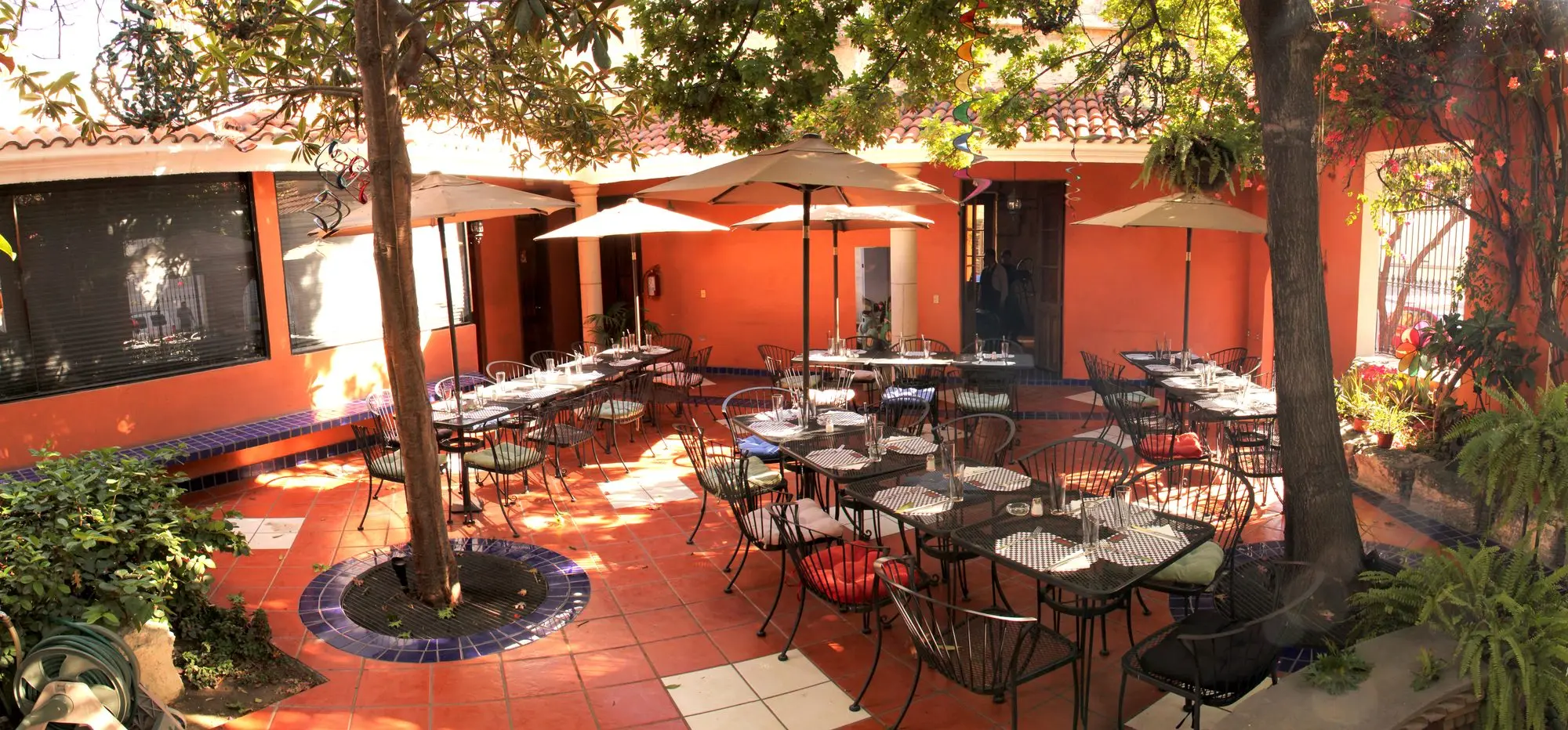El Jardín de día, con las sombrillas abiertas y el árbol en el centro