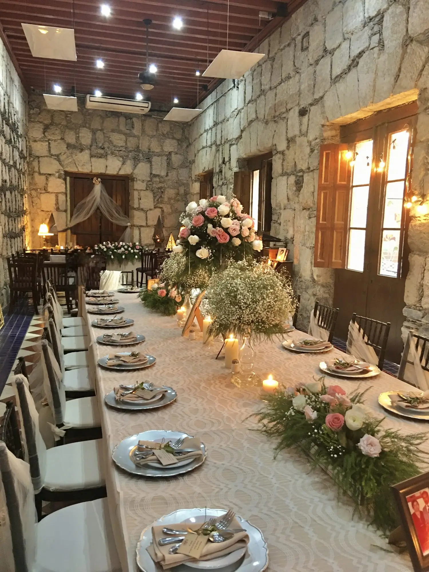 Una mesa imperial vestida de blanco y flores, montada para una boda en el Romancera