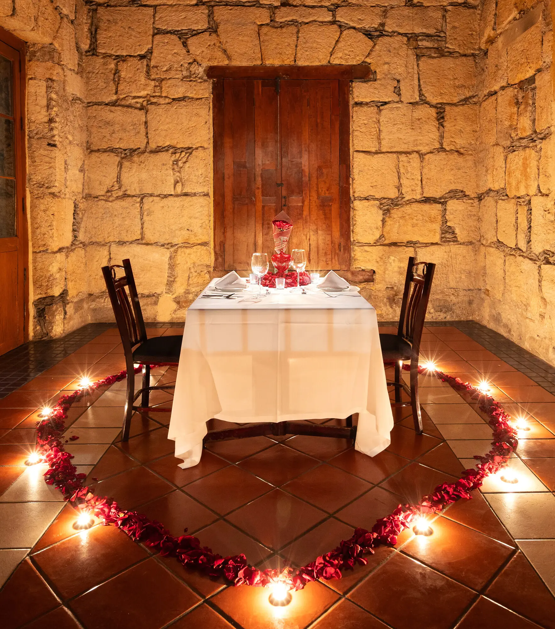 Montaje romántico con corazón de pétalos y velas